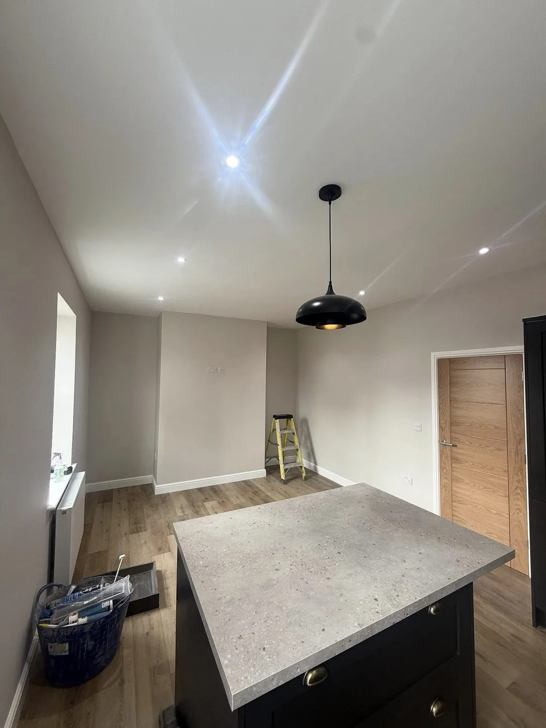Kitchen island with pendant light and recessed downlights above