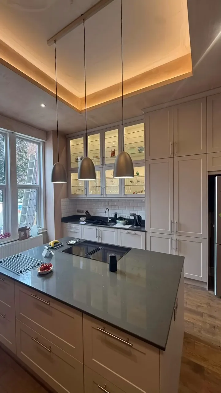 Completed kitchen with illuminated cabinets, pendants and recessed lighting