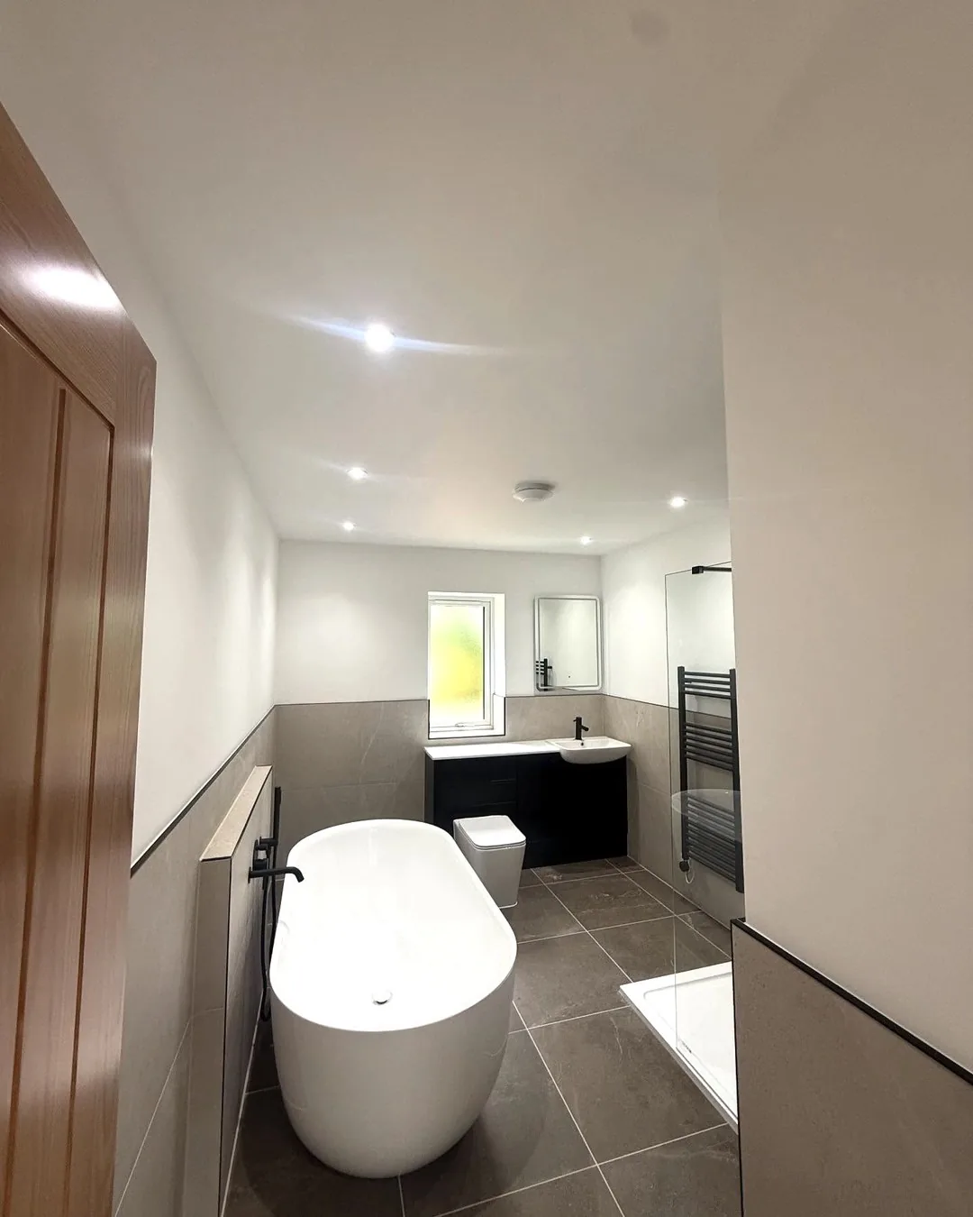 Finished new-build bathroom with freestanding bath and recessed lighting