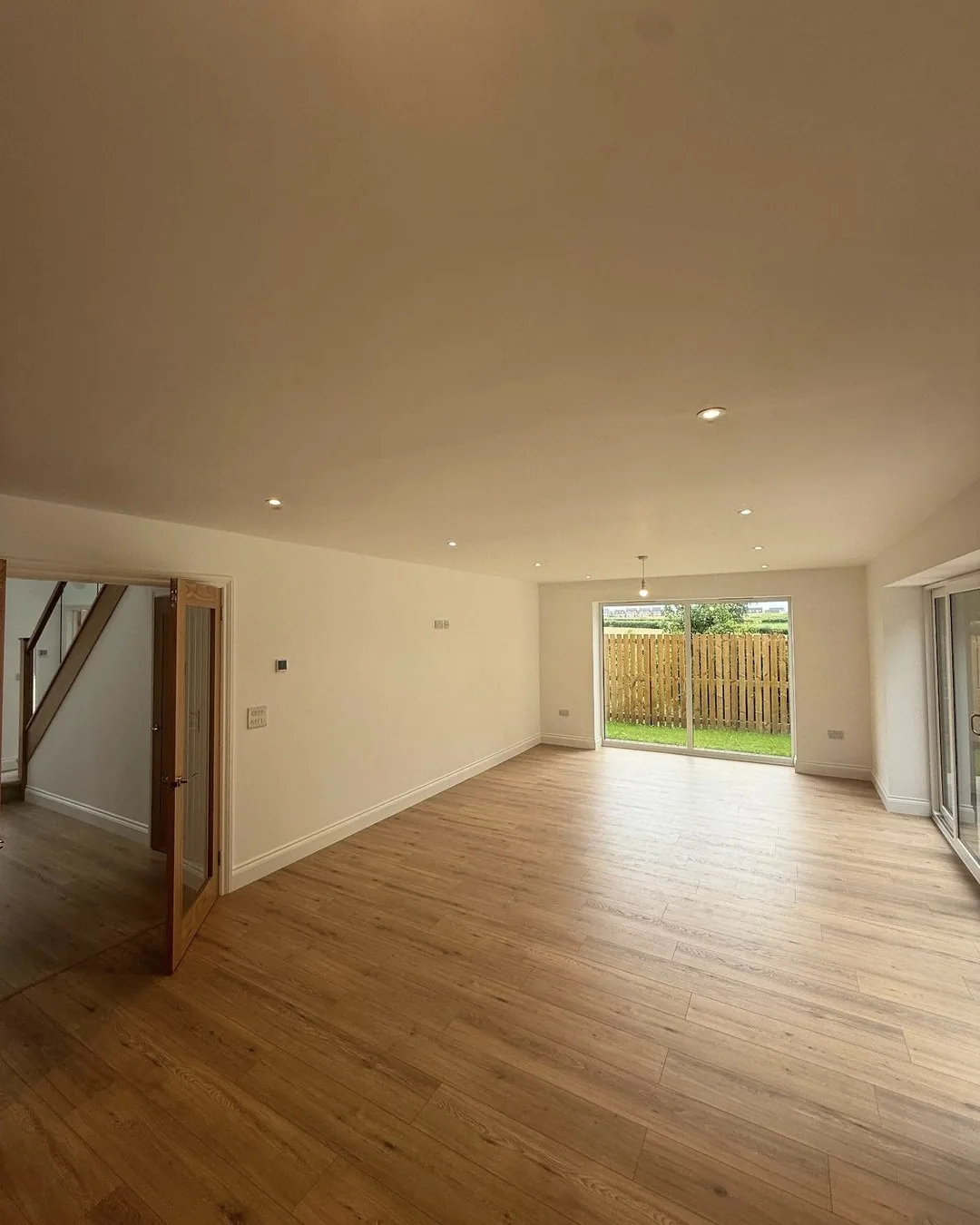 Open-plan living area with completed ceiling lighting