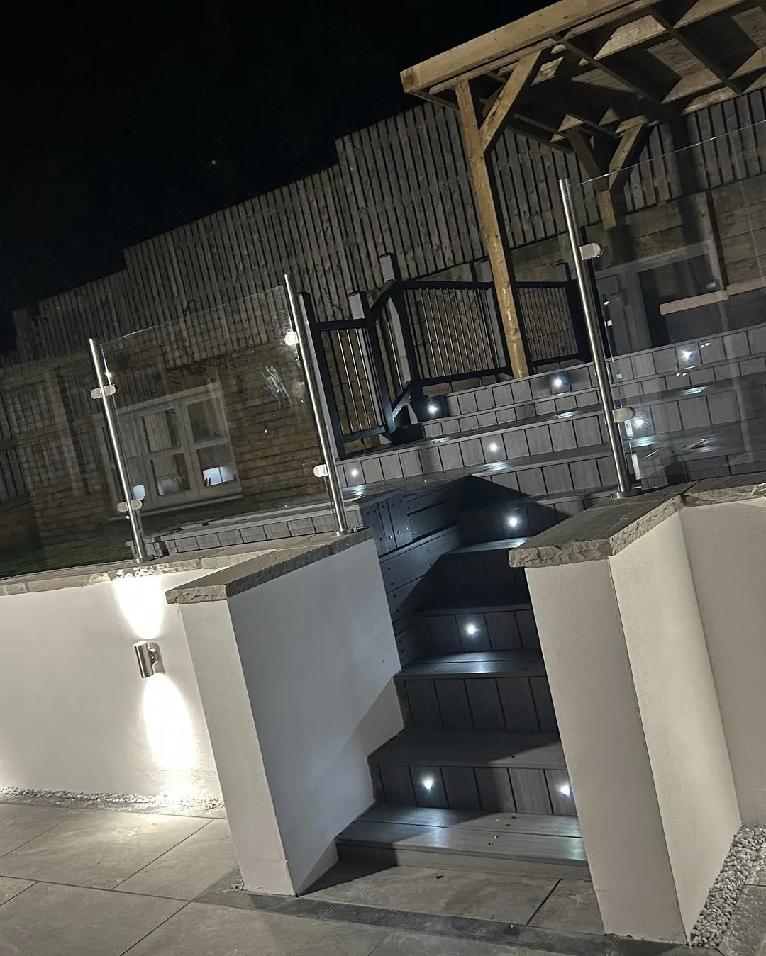 Illuminated decking staircase with integrated step lights and glass balustrade